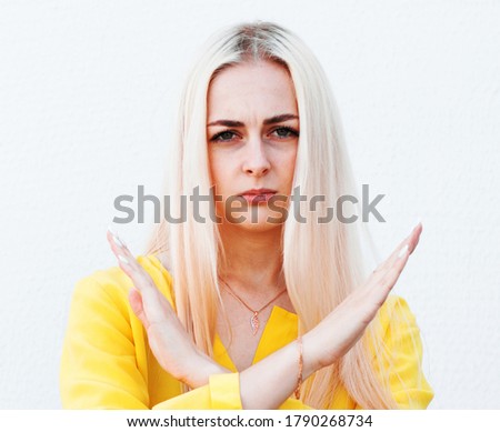 Young woman gesturing stop or saying no, cross her arms isolated on white background. stop violence concept