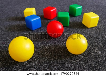 Geometric toys lie on the carpet. Building blocks with balls and cubes. Selective focus, close-up. Education concept, preschool learning toys