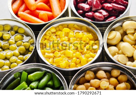 Canned vegetables in opened tin cans on kitchen table. Non-perishable long shelf life foods background Royalty-Free Stock Photo #1790292671
