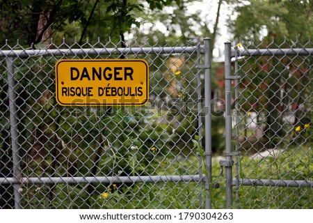A fence with a sign that says danger risk of scree