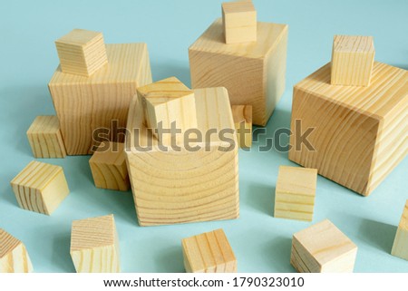 many wooden cube of different size on blue background. Construction and developing consept. mockup for designers.