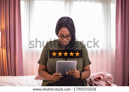 African woman holding tablet with five star services rating satisfaction. Royalty-Free Stock Photo #1790335058