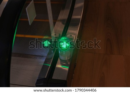 Green arrow to illuminate escalator movement indicator.