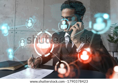 A man in office signing papers while talking mobile and social media hologram. Double exposure. Formal wear.