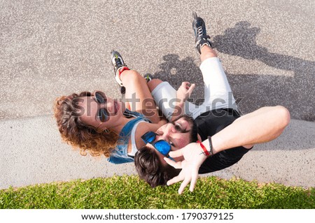 Young couple wearing roller skates and enjoying of being together. View from above