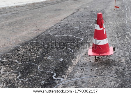 road construction or repair - laying a new layer of asphalt, marking the level for increased accuracy and warning signs cone