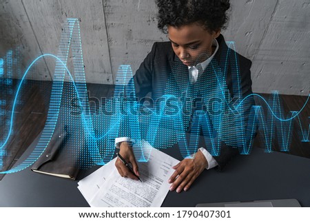 A woman signs contract and financial chart hologram. Concept of stock market analysis. Multiexposure. International business.