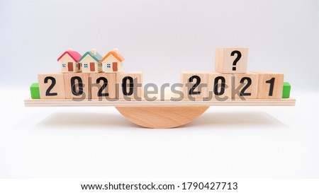 Scale comparing 2020 and 2021 housing market trends, question on real estate economics future plan and property value analysis. Business concept of forecasting financial effect from coronavirus crisis Royalty-Free Stock Photo #1790427713