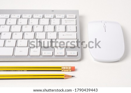 View of keyboard and mouse of a modern computer with pencils.