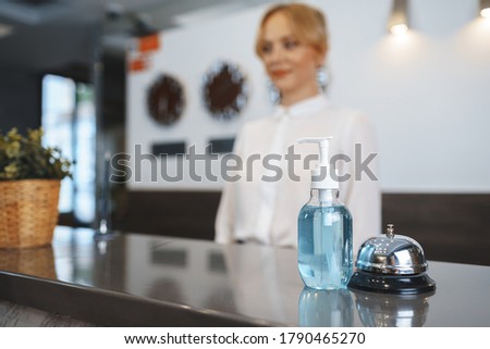 Hand sanitizer bottle on hotel reception desk
