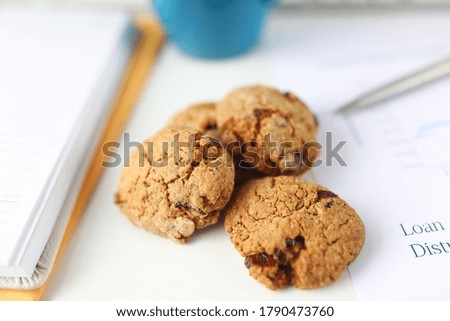 Close-up of oatmeal cookies on business papers. Macro shot of delicious homemade biscuits. Sweets and dessert for tea or coffee. Bakery and confectionery concept