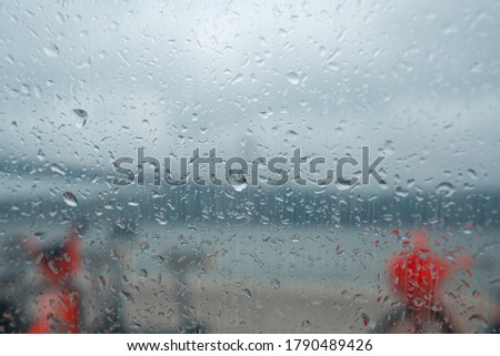 Background of water drops on a window glass in a rainy day.
Background contains bikes and a beautiful river over a river.