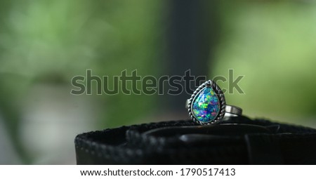 Opal is a silver ring decorated with an opal gem.