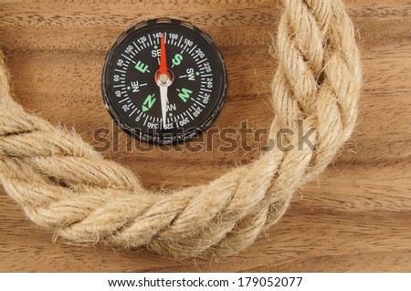 Ship rope and compass on wooden background 