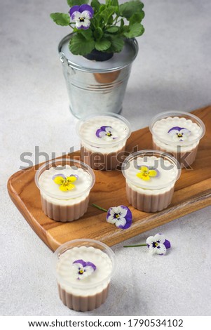 Puding bunga gelas. Edible flower pudding cup. On the top side, clear pudding with edible flower, Middle part is milk flavor and the bottom side is chocolate flavor.