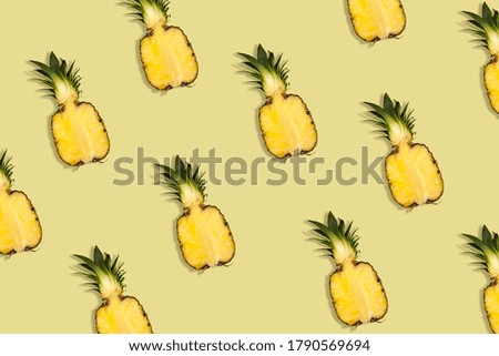 Pattern of fresh pineapple halves on a yellow background. Summer concept. Flat lay, top view.