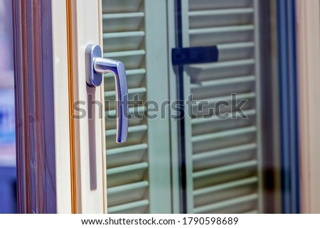 Metal door handle mechanism on window; note shallow depth of field