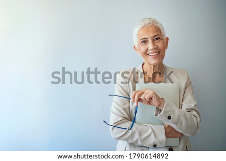 Beautiful mature business woman isolated over grey background. Attractive middle aged woman with beautiful smile. Portrait of mature business woman smile while standing against grey background. Royalty-Free Stock Photo #1790614892