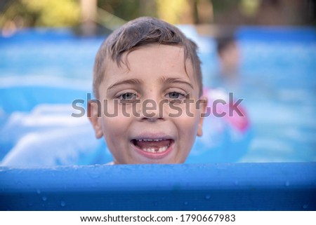 Portrait of a beautiful boy in the pool looking at the camera