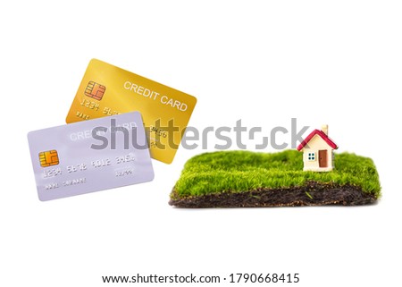 miniature family and miniature house with red roof on green grass and mock up credit card isolated on white background.