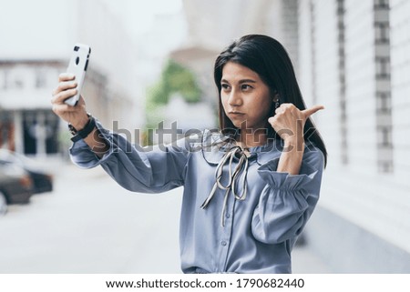 Happy young woman taking selfie. Woman taking selfie photo with a smarphone in the city