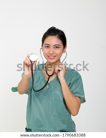 Young Asian female doctor wearing apron uniform tunic hold stethoscope