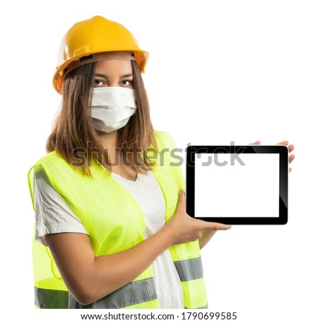 Amused young woman in yellow hardhat, green reflective vest and lumberjack shirt
