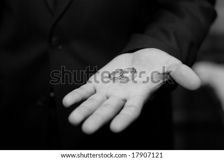 black-and-white picture of two wedding rings on a man's palm