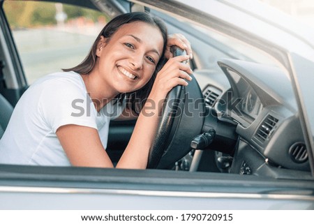 Portrait of confident young woman in the new car