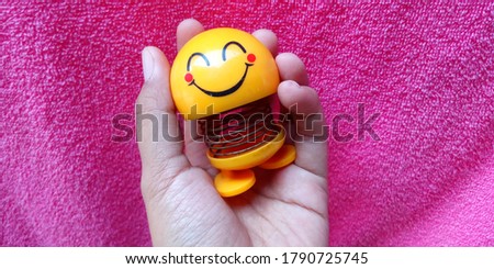 photo of a smiling toy on a flower. perfect to catalog, product ads, wallpaper, website and etc.