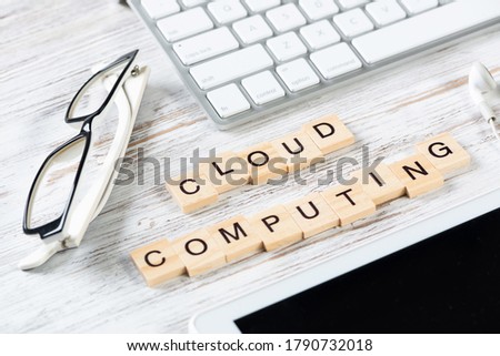 Cloud computing concept with letters on cubes. Still life of workplace with supplies. Flat lay vintage white wooden desk with computer keyboard and tablet computer. Data storage service.