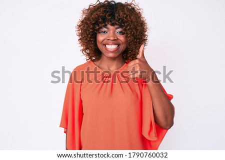 Young african american woman wearing casual clothes smiling happy and positive, thumb up doing excellent and approval sign 
