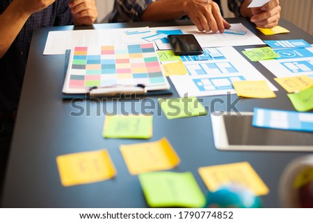 The designer sketches the application's layout scheme on the desk.