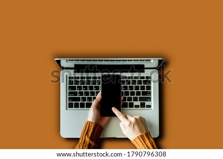 Woman hand using smartphone and laptop isolated on background.
