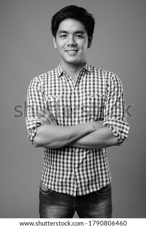Portrait of young handsome Filipino hipster man