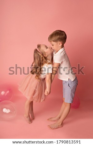 Happy child girl and boy on a pink background with balloons. Celebration. birthday