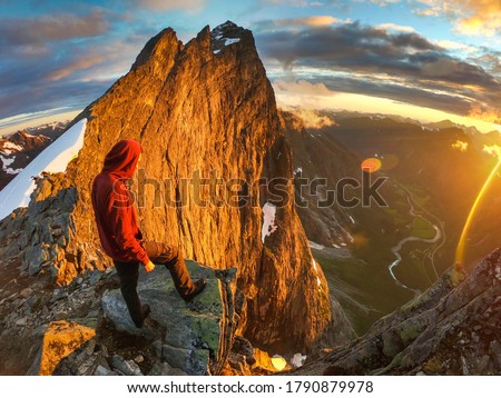 Man standing on the cliff of Trollveggen Royalty-Free Stock Photo #1790879978