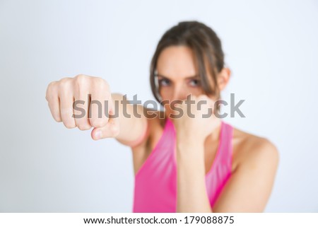 Young sports attractive woman showing boxing motion in the studio