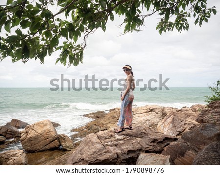 Samed, Thailand. Asian woman traveler on a cliff rock with beautiful seascape.  