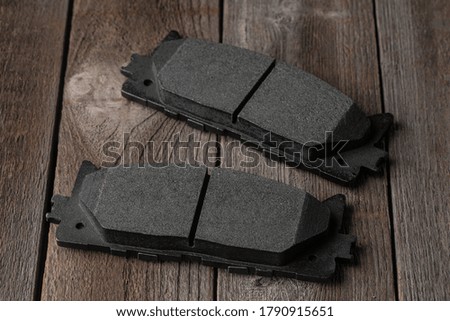 Close-up on friction pads on wooden background. Spare details for braking system of car.