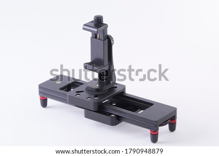 Video slider photographed in studio with phone holder in front of white background.