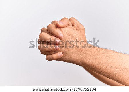 Hand of caucasian young man showing fingers over isolated white background praying with both hands clasped, fold fingers religious gesture