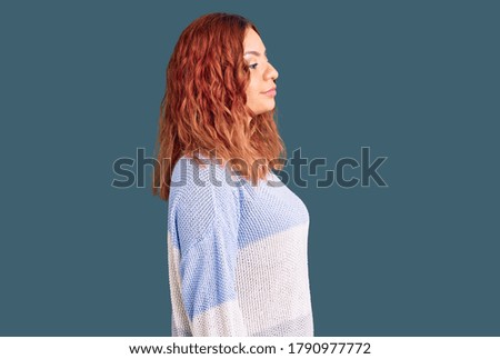 Young latin woman wearing casual clothes looking to side, relax profile pose with natural face and confident smile. 