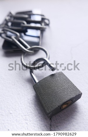 Smart Phone With Padlock And Chain Over White Background.