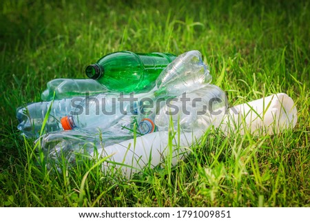 Plastic bottles in the grass. The concept of environmental pollution. Clean, eco-friendly.