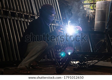 A man welding a broken iron chair