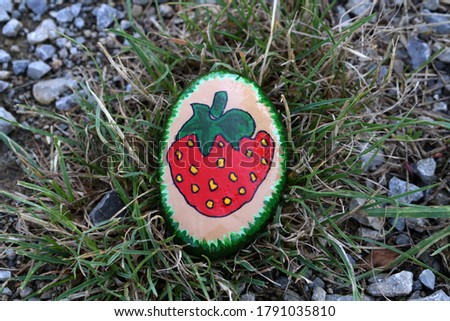 A painted hiking stone is left on the walking path for passersby to see