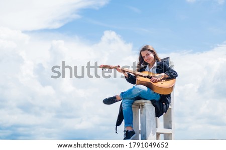 music school classes. small guitar player on sky background. country music style. string musical instrument. play on acoustic guitar. little girl play guitar she loves music. copy space. Royalty-Free Stock Photo #1791049652