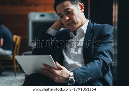 Handsome business man looking at tablet stock photo