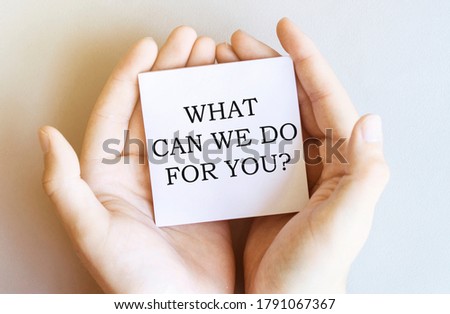white paper with text What Can We Do For You in male hands on a white background
